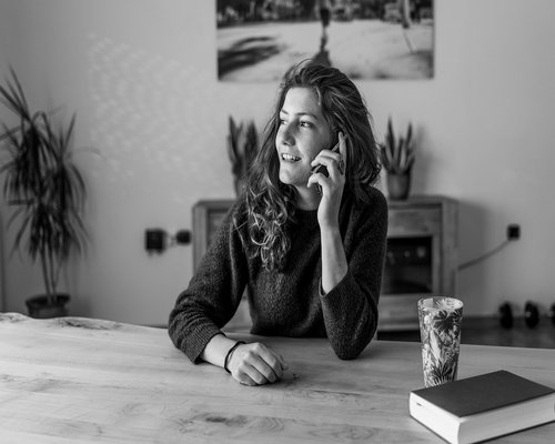 A person holding a smartphone at an ergonomic distance while sitting on a couch