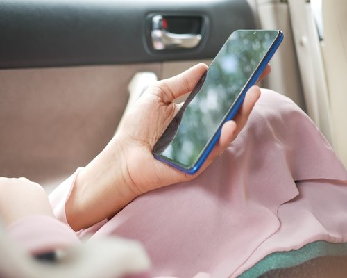Close up of a smartphone screen being used in a moving vehicle